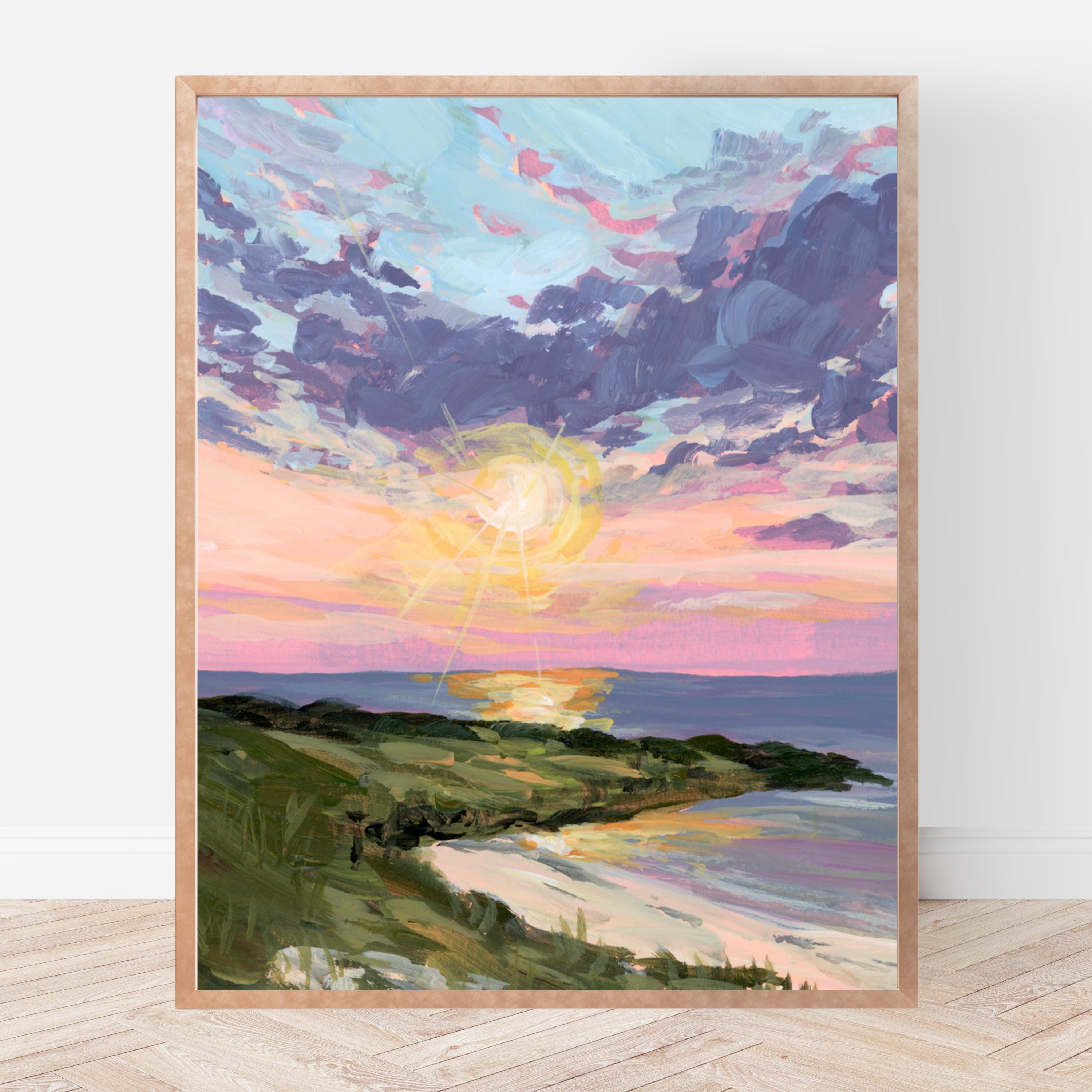 Framed print of a sunset over a coastal landscape with a wooden frame.