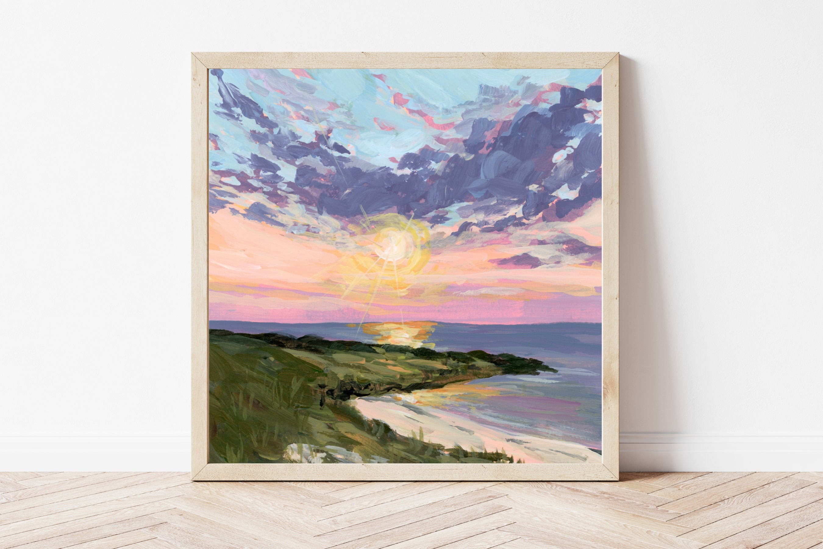 Framed artwork of a sunset over a beach with a colorful sky.