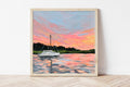 Framed painting of a sailboat on water with a colorful sunset sky.