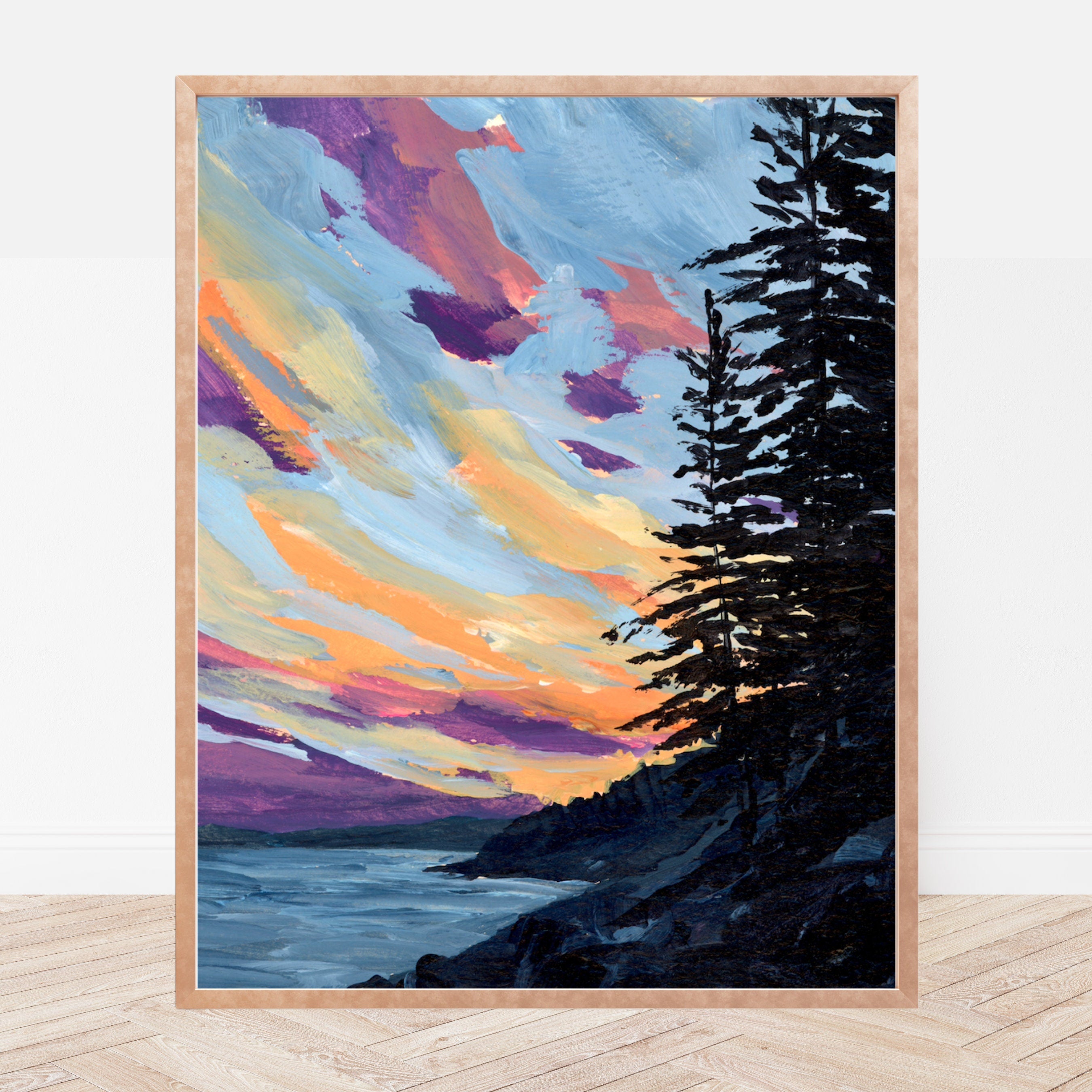 Framed art print of a sunset over the ocean in Acadia, Maine with the silhouette of pine trees in the foreground.