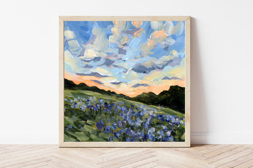 Framed landscape print of a Texas bluebonnet field underneath a blue sky fading into an orange sunset. 