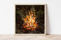 Framed painting of a campfire on a white wall