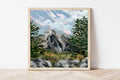 Framed painting of a Colorado mountain landscape with towering pine trees on a white wall.