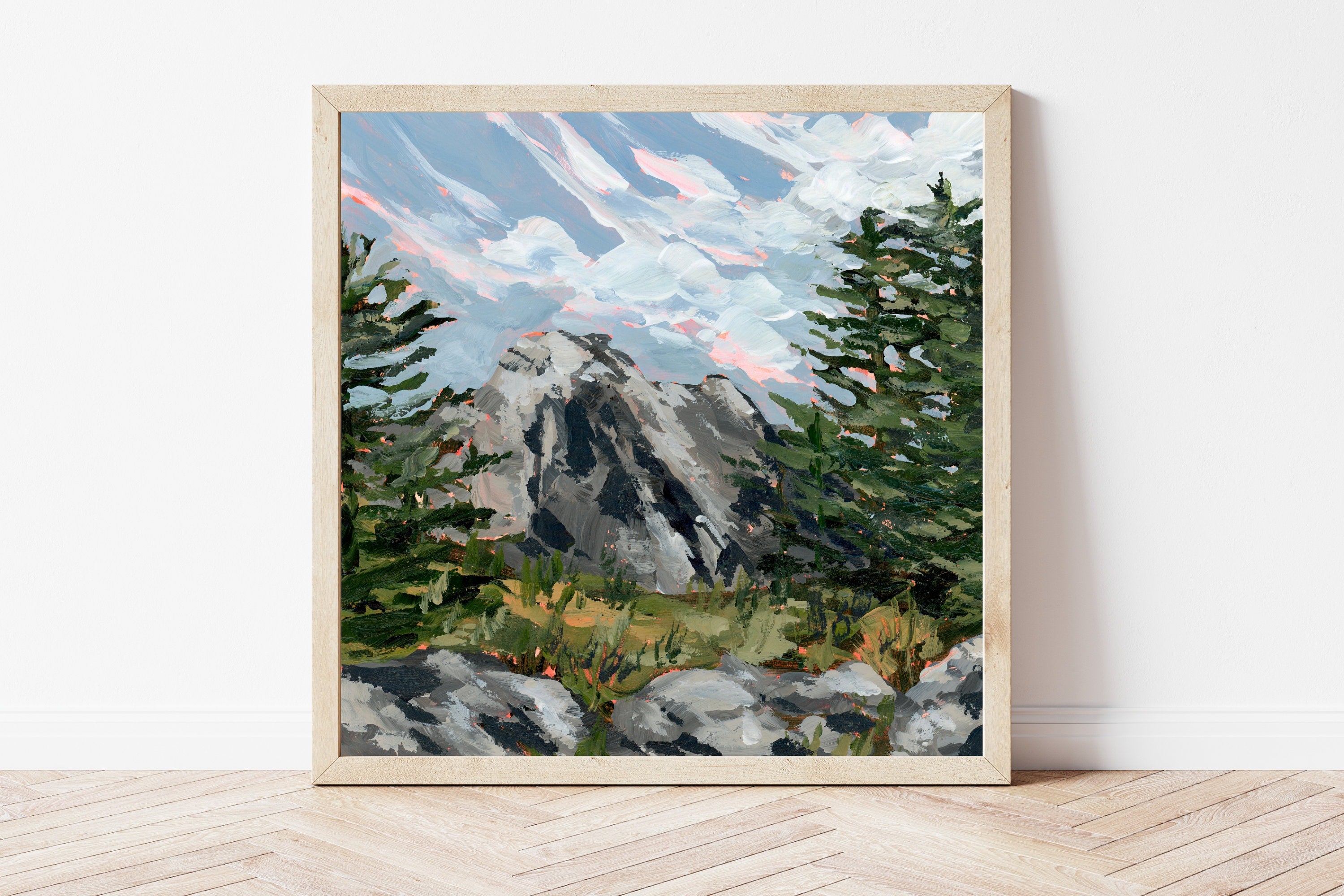 Framed painting of a Colorado mountain landscape with towering pine trees on a white wall.