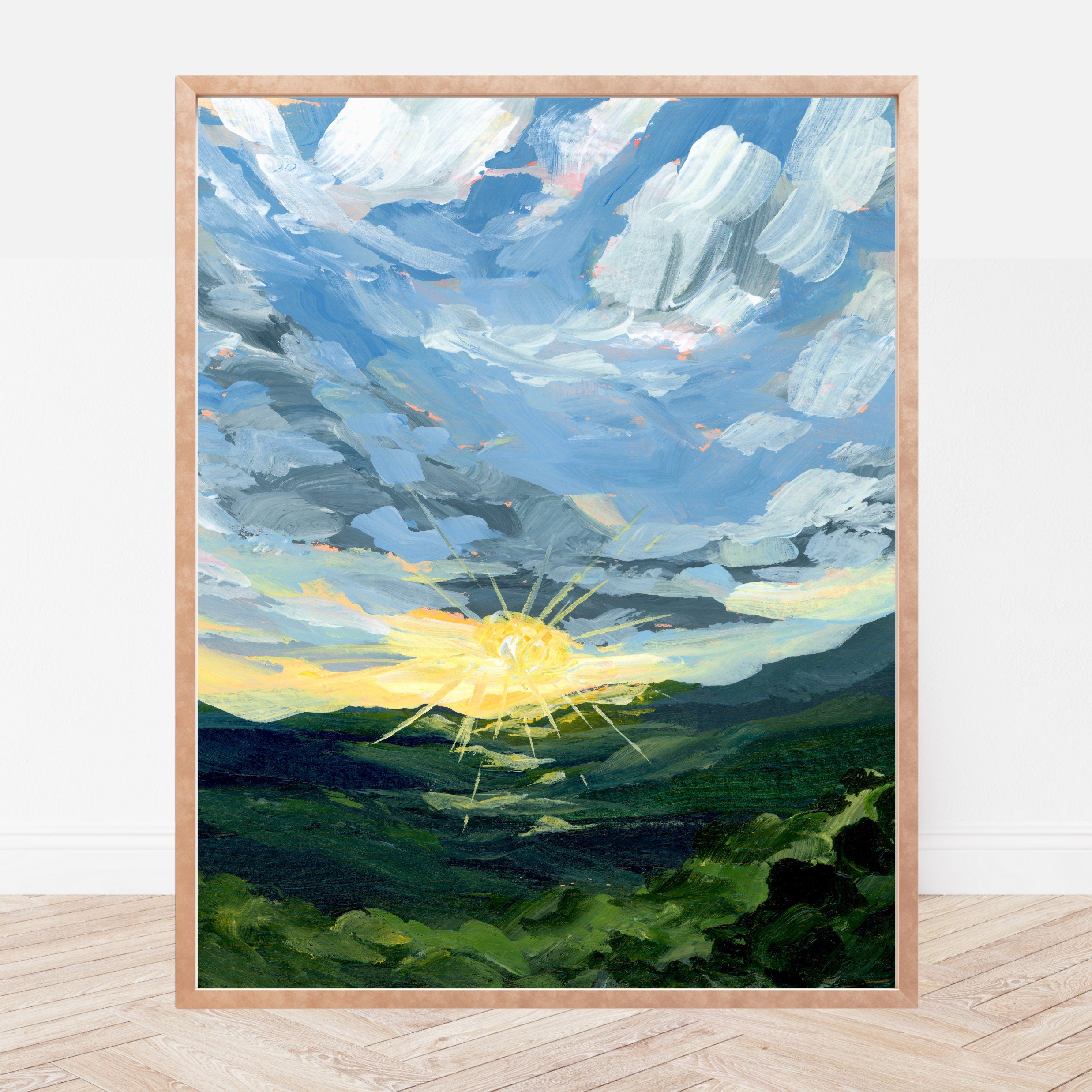 Framed painting of a sun rising over a smoky mountain landscape with a blue sky.