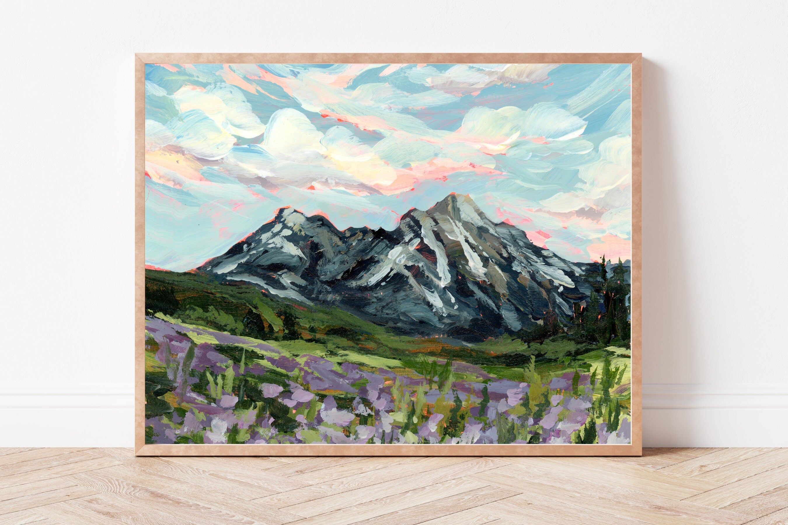 Framed painting of a mountain landscape with purple wildflowers in the foreground.