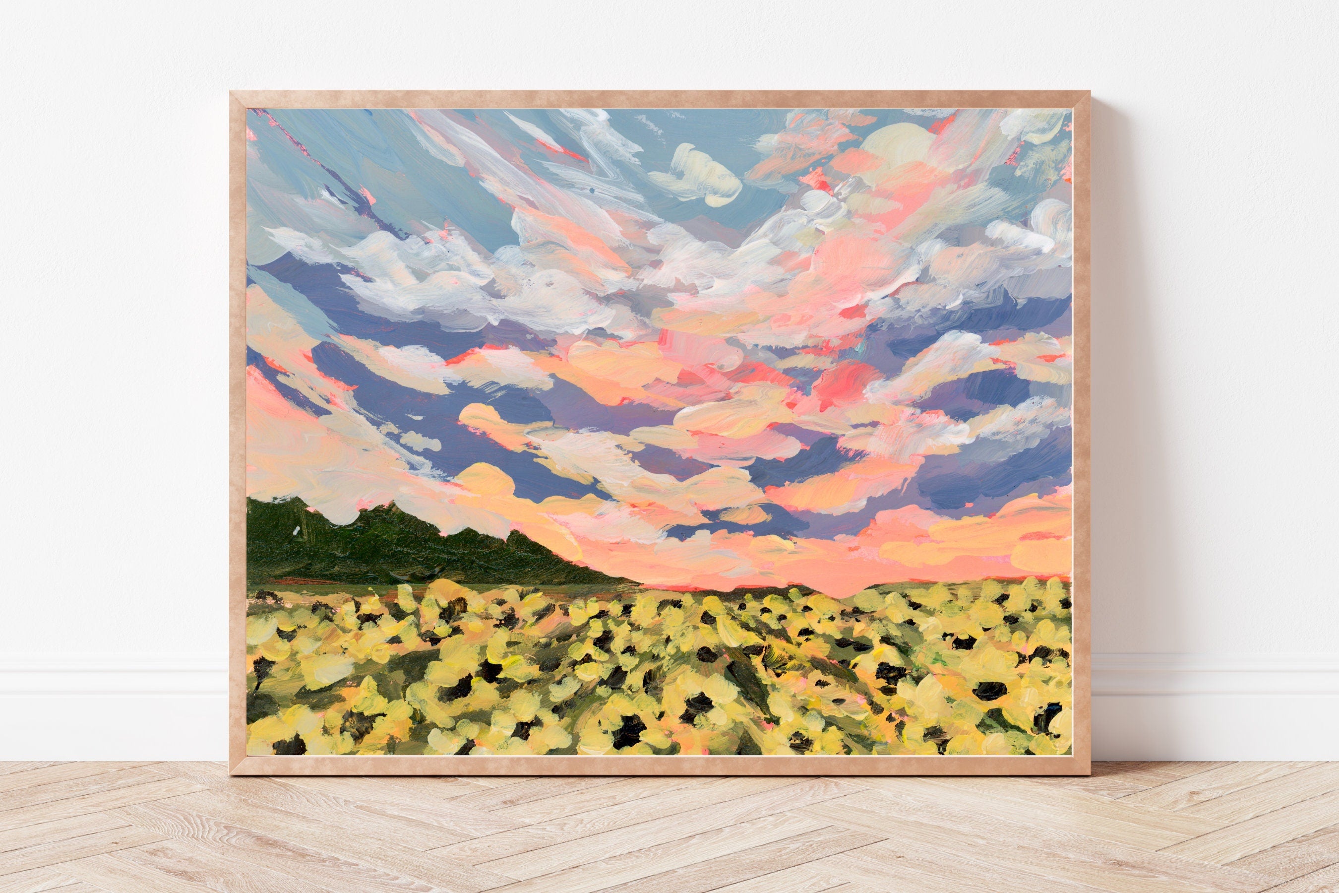 Framed art print of a sunflower field beneath a vibrant sunset. 
