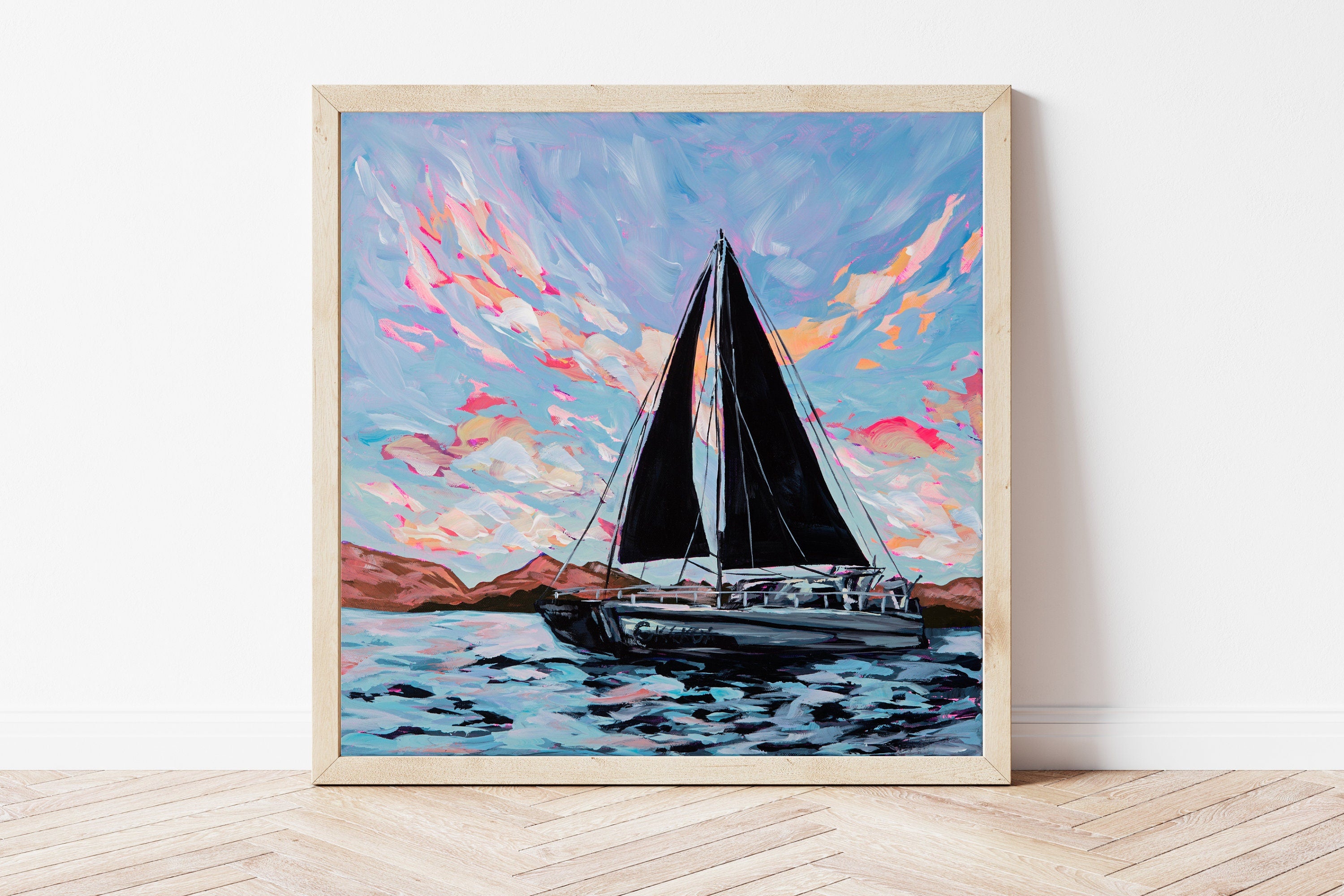 Framed painting of a large black sailboat in the USVI with a bold, colorful sky.