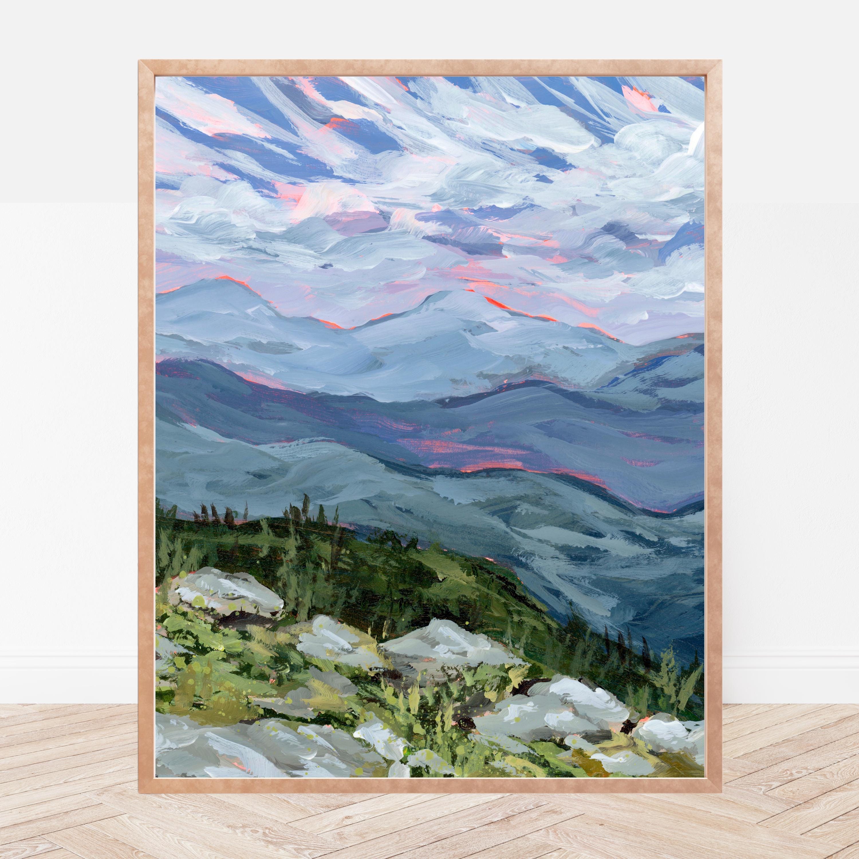 Framed print of a rocky ledge overlooking the White Mountains of New Hampshire. The frame is sitting on a wood floor resting against a white wall. 