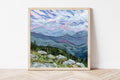 Framed print of a landscape overlooking the White Mountains in New Hampshire underneath a blue sky. 