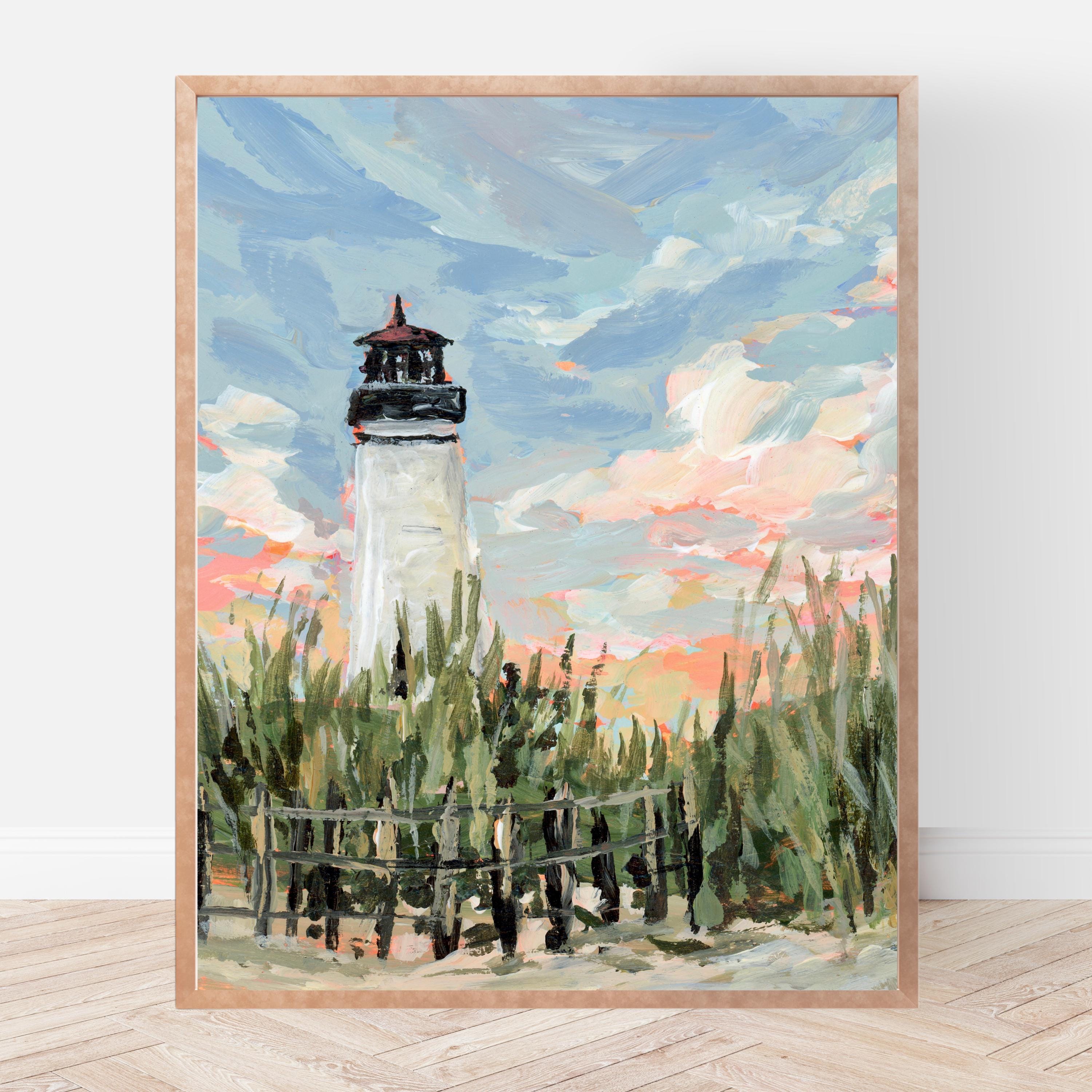 Framed painting of a lighthouse with a colorful sky and grassy foreground.