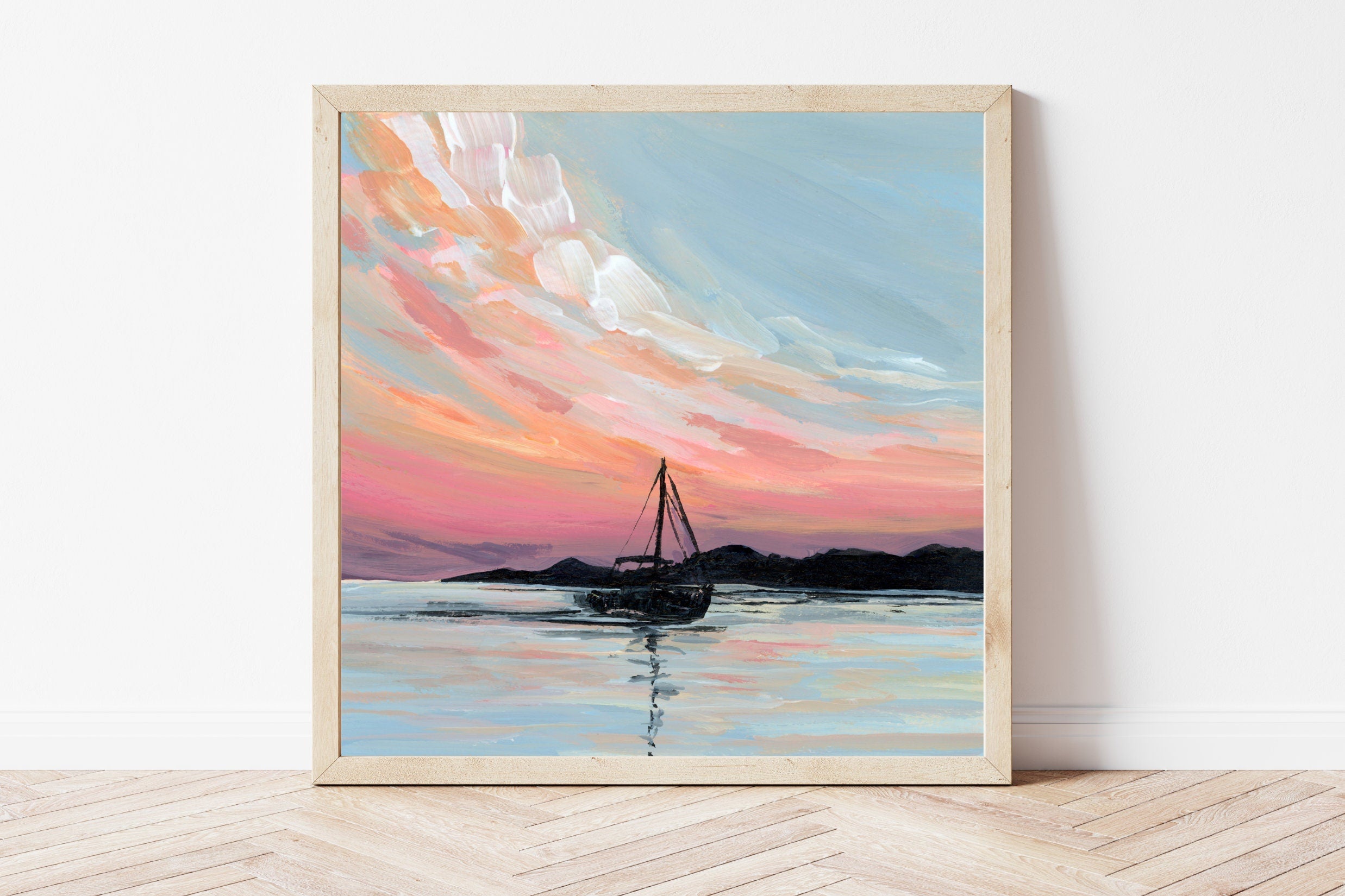 Framed artwork of a sailboat on water with a colorful sky.