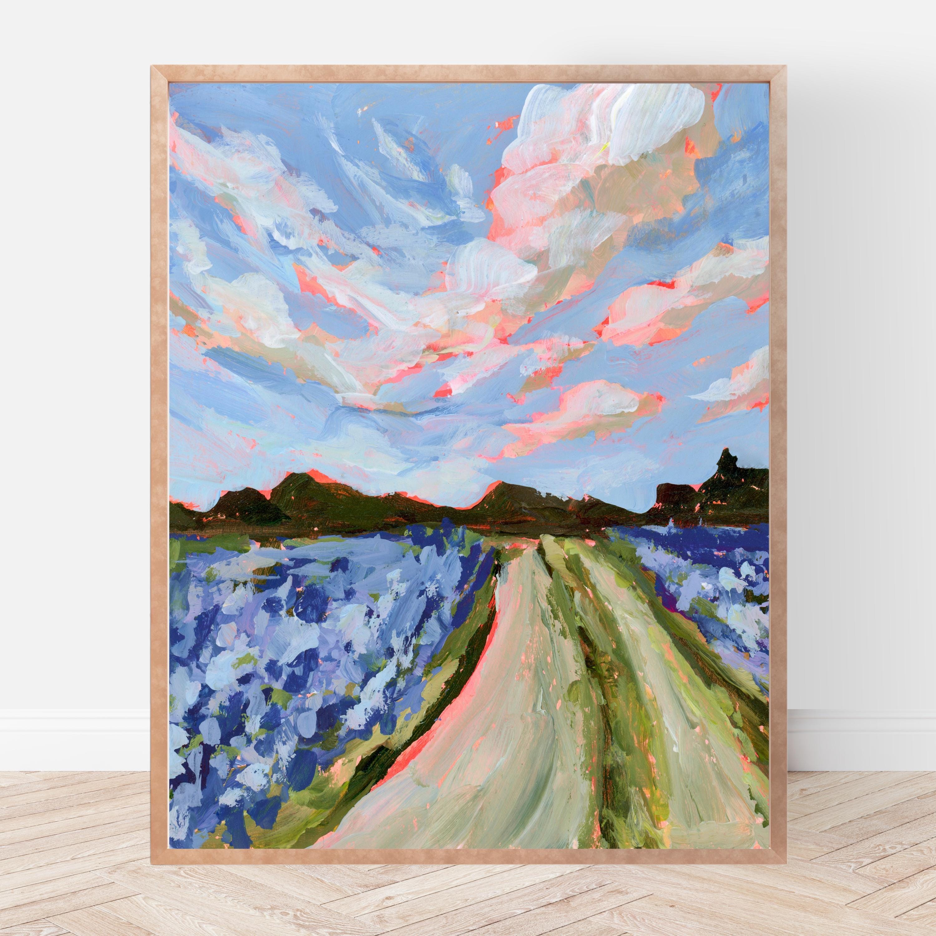 Framed painting of a Texas hill country landscape with a blue sky, pink clouds, a field of bluebonnets. 
