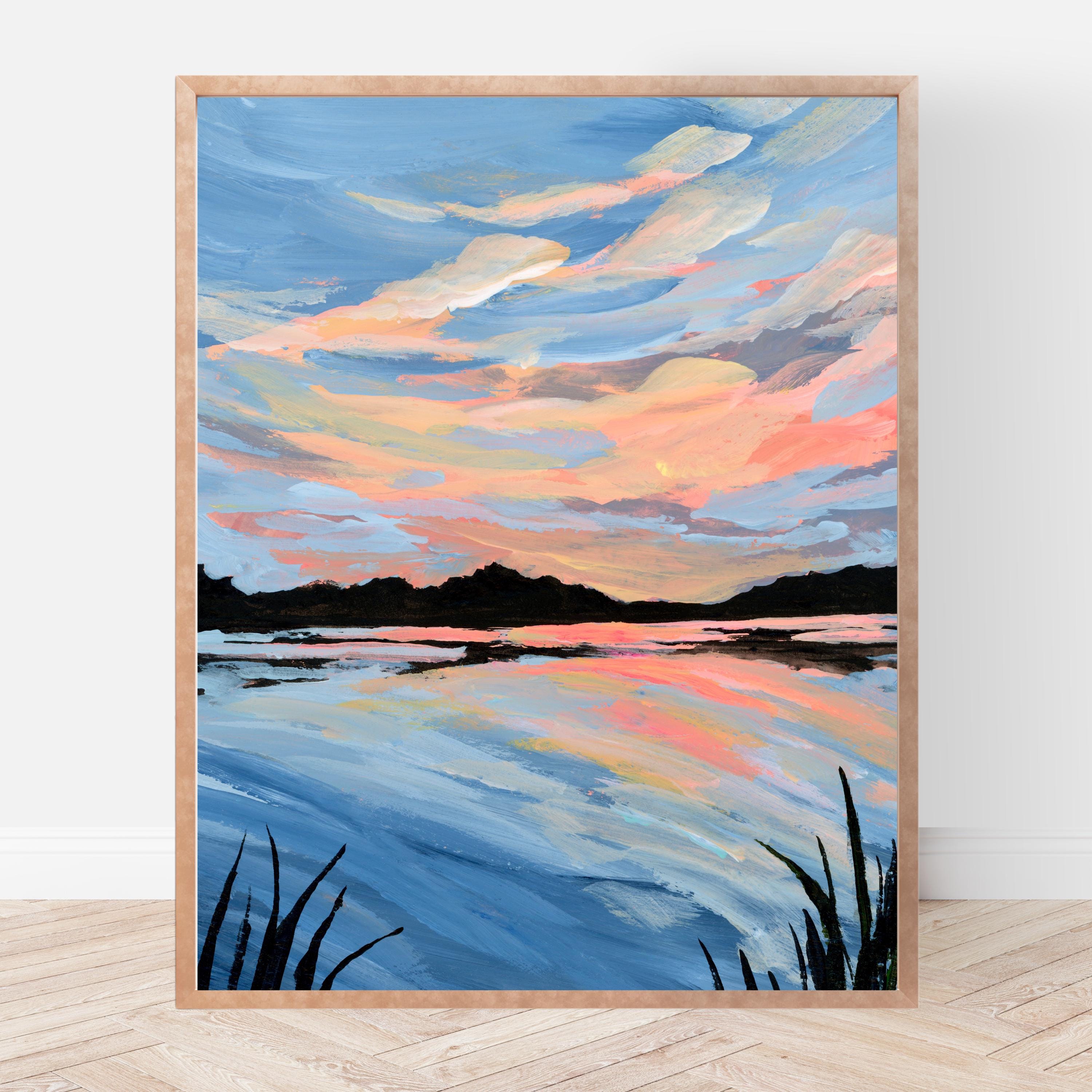 Framed painting of a sunset over a lake with a wooden frame.