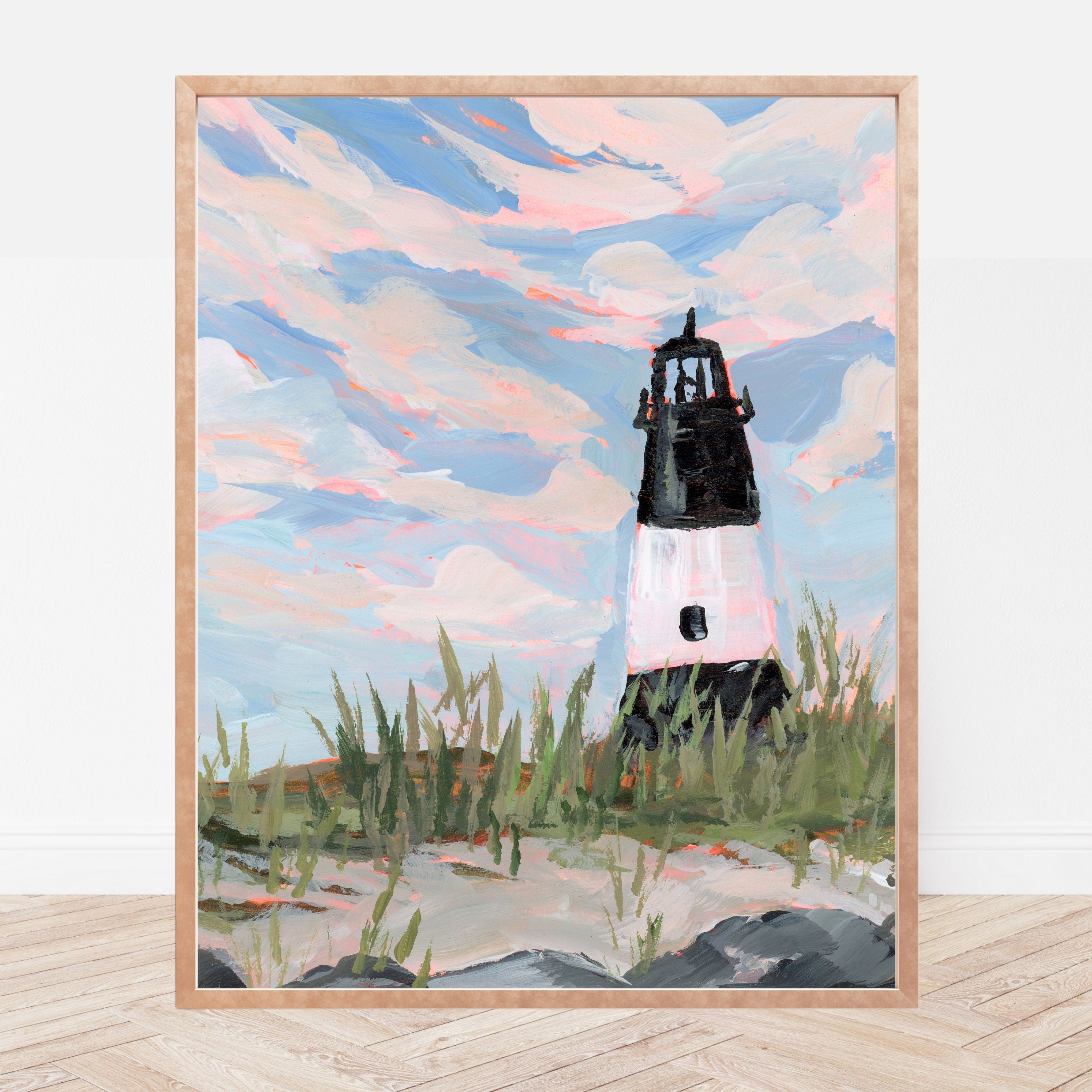 Framed artwork of a black and white striped lighthouse surrounded by beach grass against a blue sky.