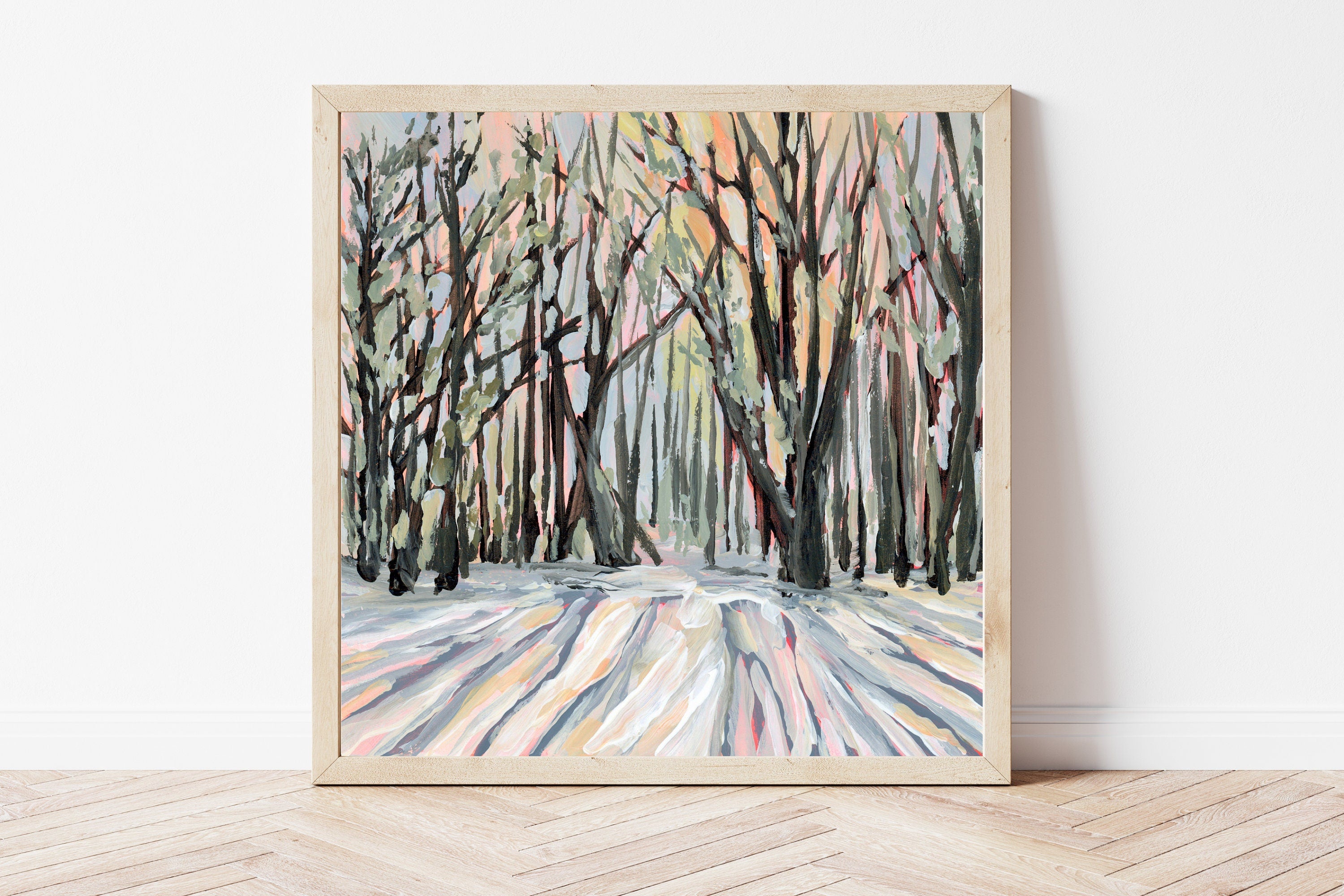 Framed painting of a winter forest scene with bold, defined brushstrokes on a white wall.