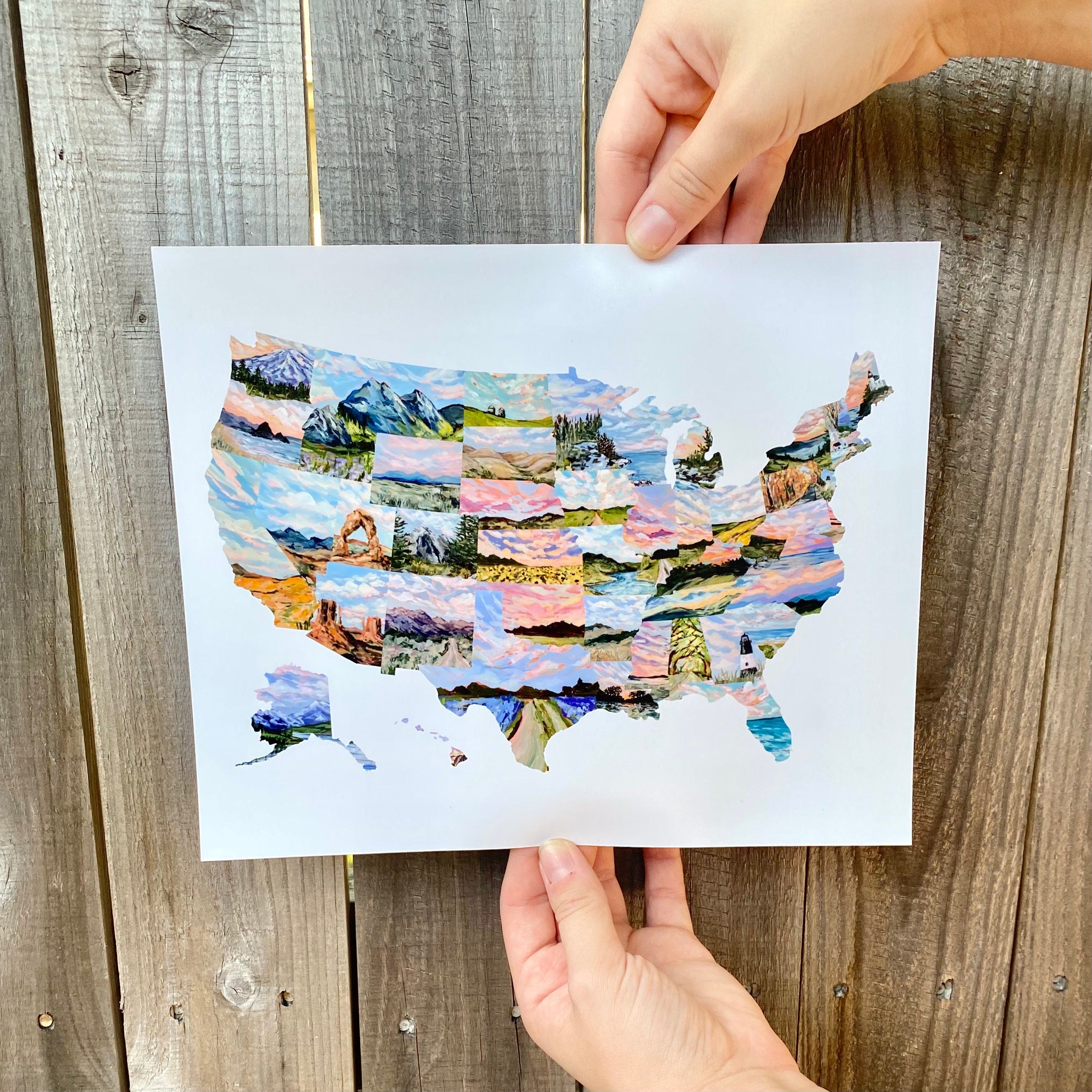 Colorful map of the United States held by a hand on a wooden surface