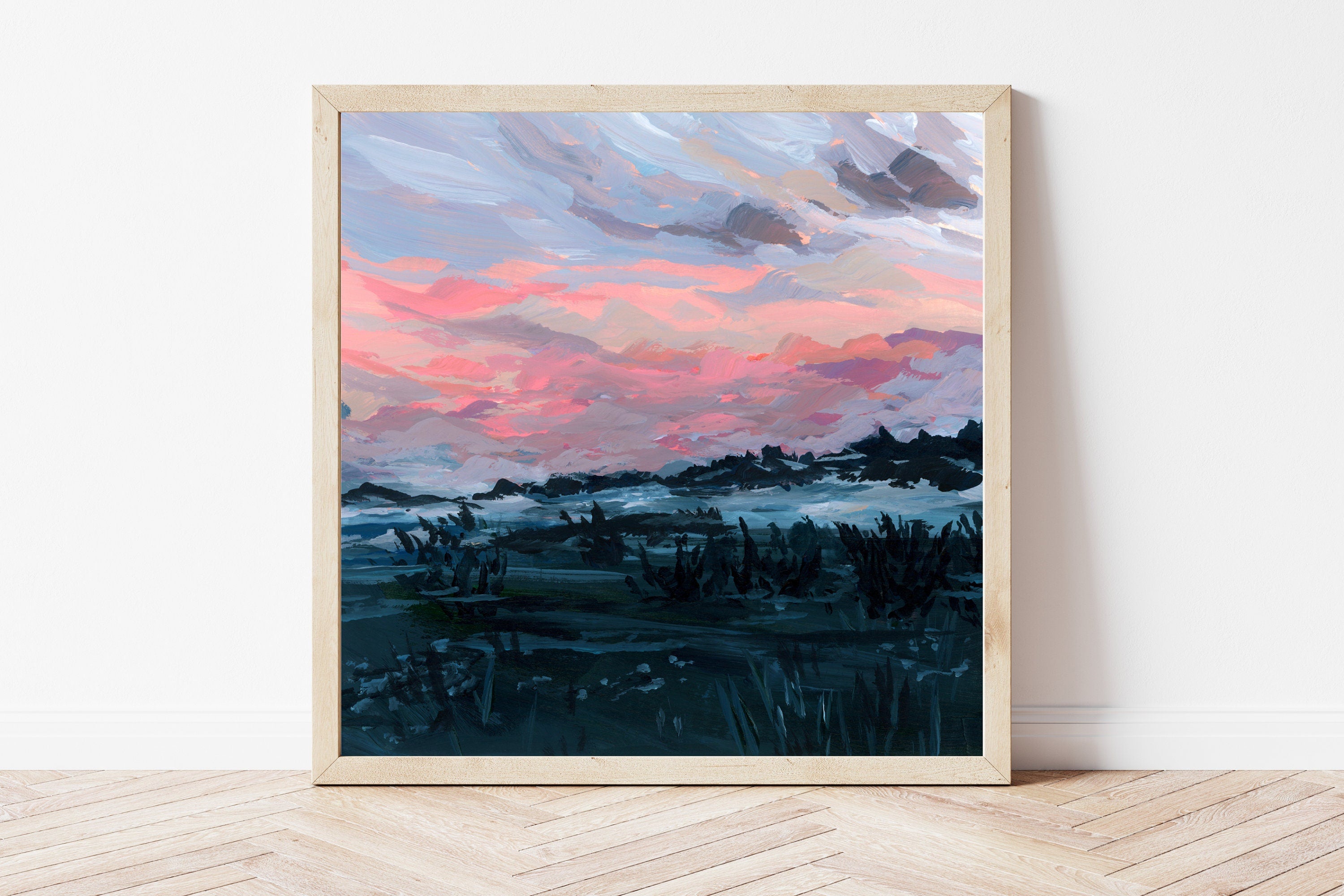 Framed art print of a hazy blue toned landscape beneath a pink morning sky. 